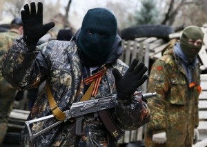 An armed man gestures in front of the police headquarters in Slaviansk